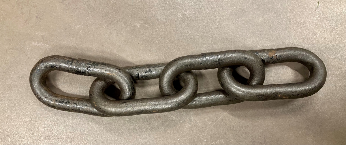 To korte lenker, en jernring, to rør. Rørene er såkalte "muffer". Jernringen er et midjejern. Nøkkelen til midjejernet medfølger.