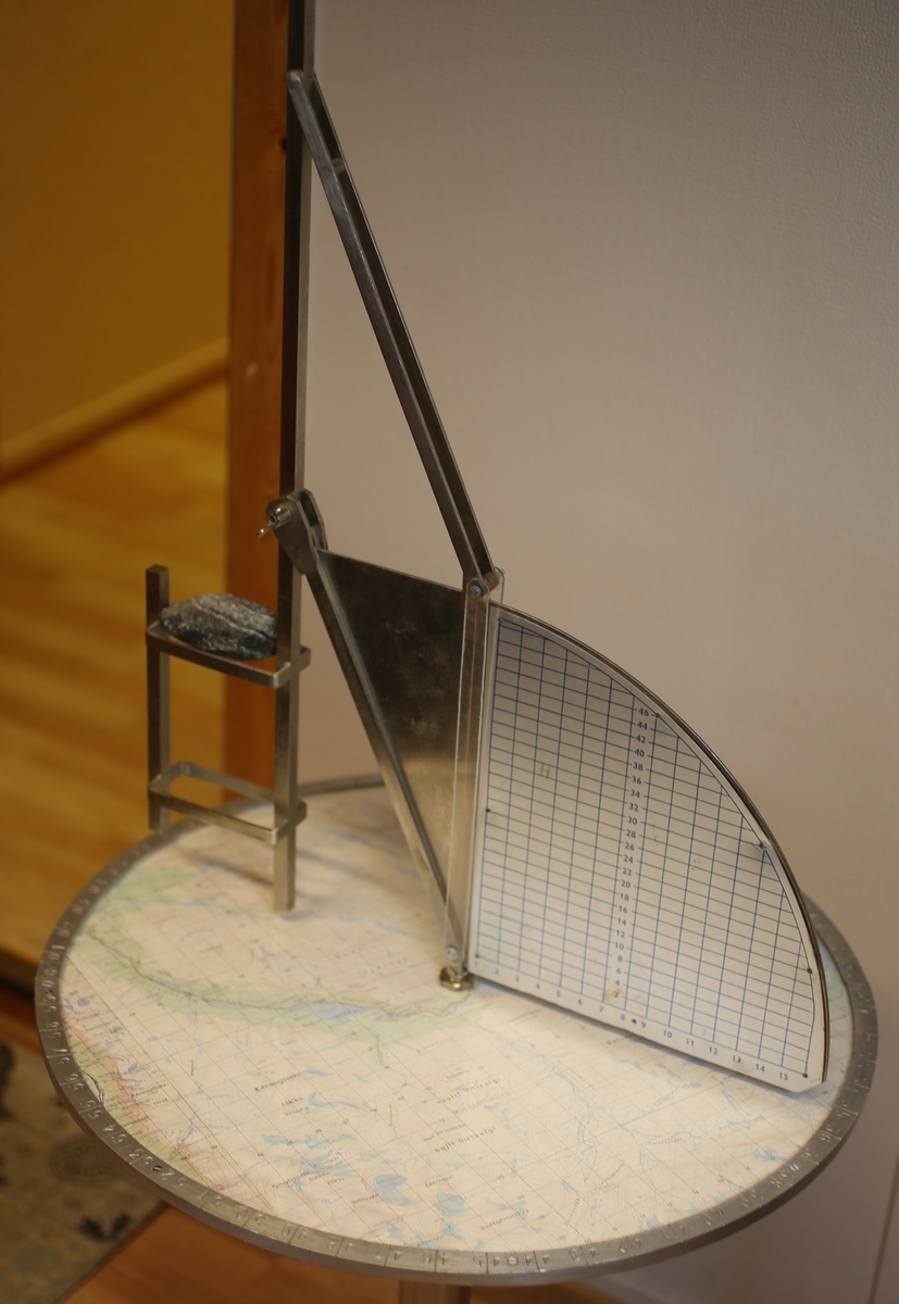 Består av plottebord og sikteoppsats. Den horisontale skiva viser kartet over luftvaktens dekningsområde, med det geografiske referansesystemet som ble benyttet ved rapportering inntegnet. I ytterkanten på skiva er retningen i grader angitt. Den vertikale plata ble benyttet ifm avlesing av flyets høyde.