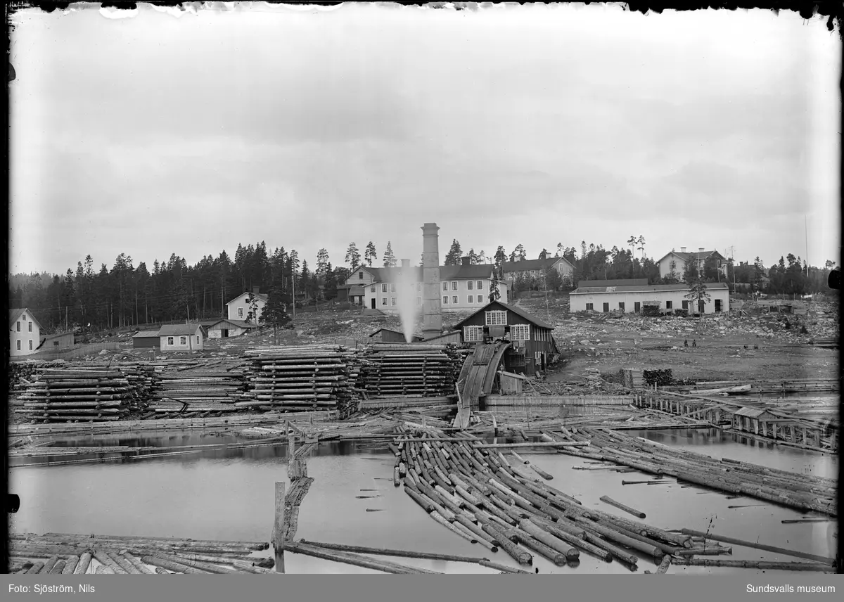 Vy från vattnet mot Stockviks sågverk (1876-1936). Bakom syns herrgården till höger samt arbetarbostäder.