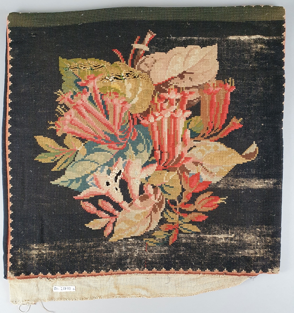 Tre broderte putetrekk med rosemotiv på svart bakgrunn. To av putetrekkene er ikke ferdig brodert.