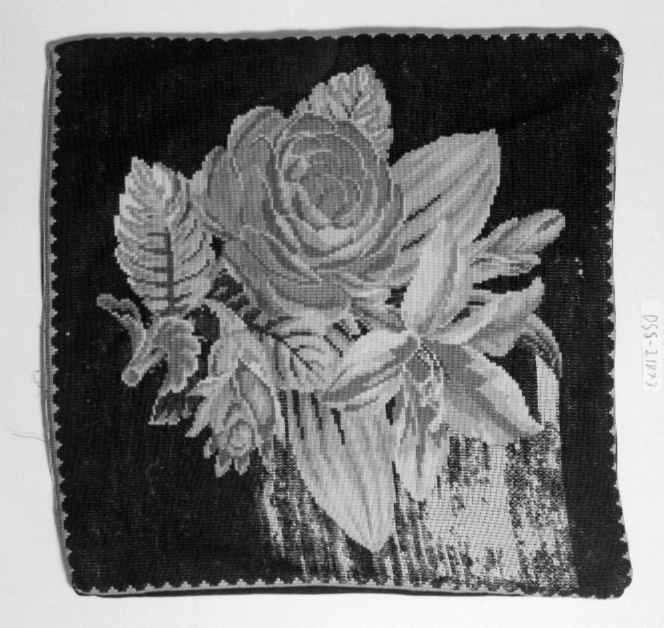 Tre broderte putetrekk med rosemotiv på svart bakgrunn. To av putetrekkene er ikke ferdig brodert.