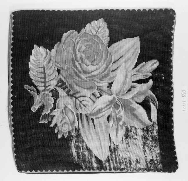 Tre broderte putetrekk med rosemotiv på svart bakgrunn. To av putetrekkene er ikke ferdig brodert.