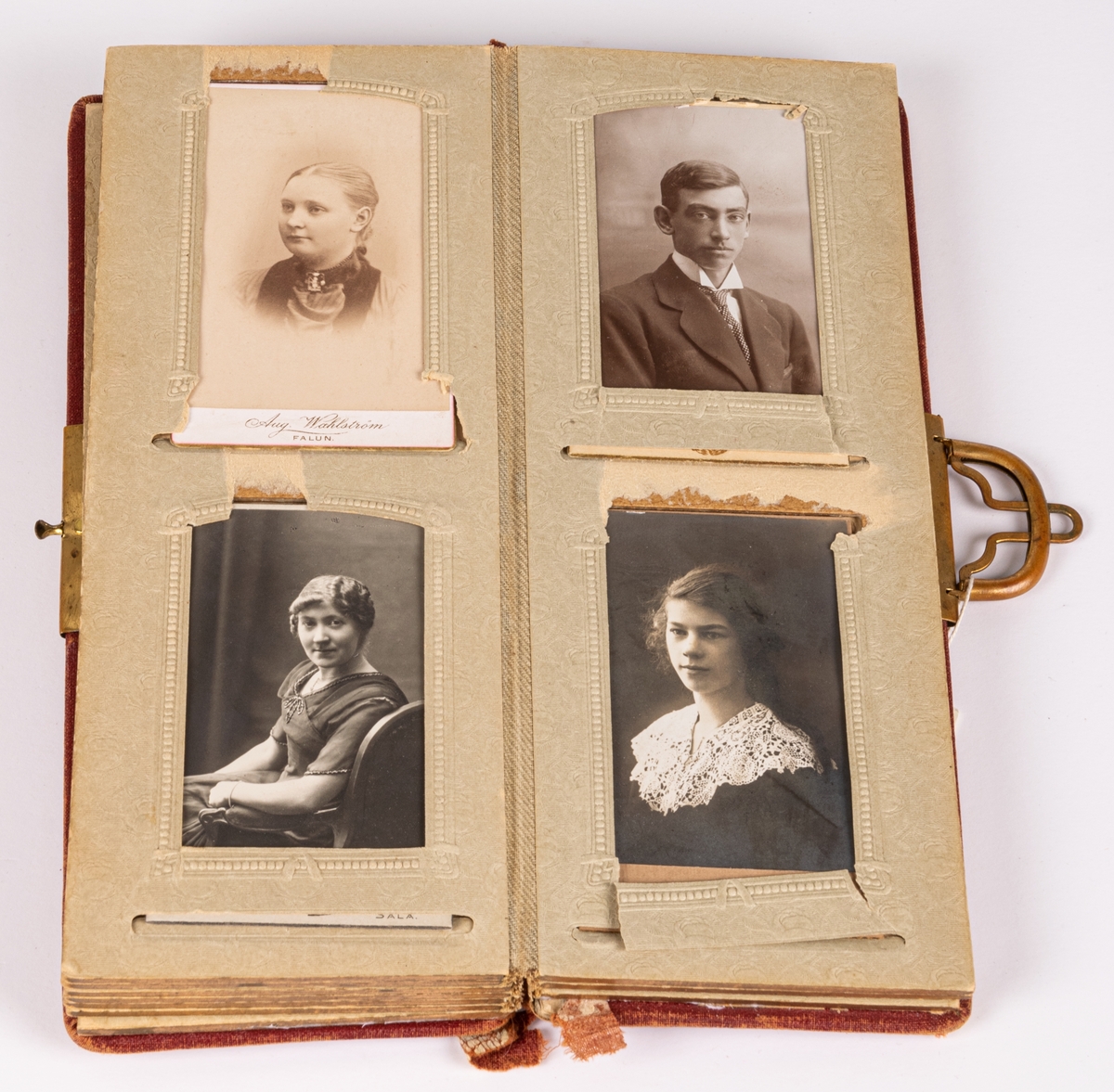 Smalt, rött fotoalbum med metallspänne, innehållande 22 visitkort. Många foton sakna. Porträtt över personer från Uppsala och Gästrikland.
