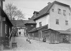 Gårdsinteriör från Stenhusgården i Linköping 1901. Stenhusbyggnaden ingick i en medeltida gård, där övriga byggnader brann ned vid den stora stadsbranden år 1700. Byggnaden är orienterad enligt det medeltida gatumönstret och står något snett mot den senare tillkomna Storgatan. Vid tiden för bilden drev Johan Oskar Andersson en diversehandel i byggnaden. Till vänster sitter tre flickor på trappan till krogen Amerika som ännu vid tiden erbjöd utskänkning av starka drycker. Sedan 1983 tjänar huset som grafikcentrum för östgötska konstnärer.