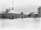 Ett sprucket glasnegativ som likafullt har värde i sitt frusna ögonblick av en svunnen tid. Vy över sydöstra delen av Stora torget i Linköping. Året är 1898 och ännu ett kvarts sekel kommer torgets sida mellan Stor- och Tanneforsgatan vara oförändrad. Den egendomliga men vackra hörnfastigheten till vänster i bild uppfördes av borgmästare Samuel Pyttner några år efter den stora stadsbranden år 1700. Med sitt centrala läge kom byggnaden tidigt att inrymma handelsbod, vid tiden för bilden Fritiof Björnsons speceri-, garn och diversehandel.