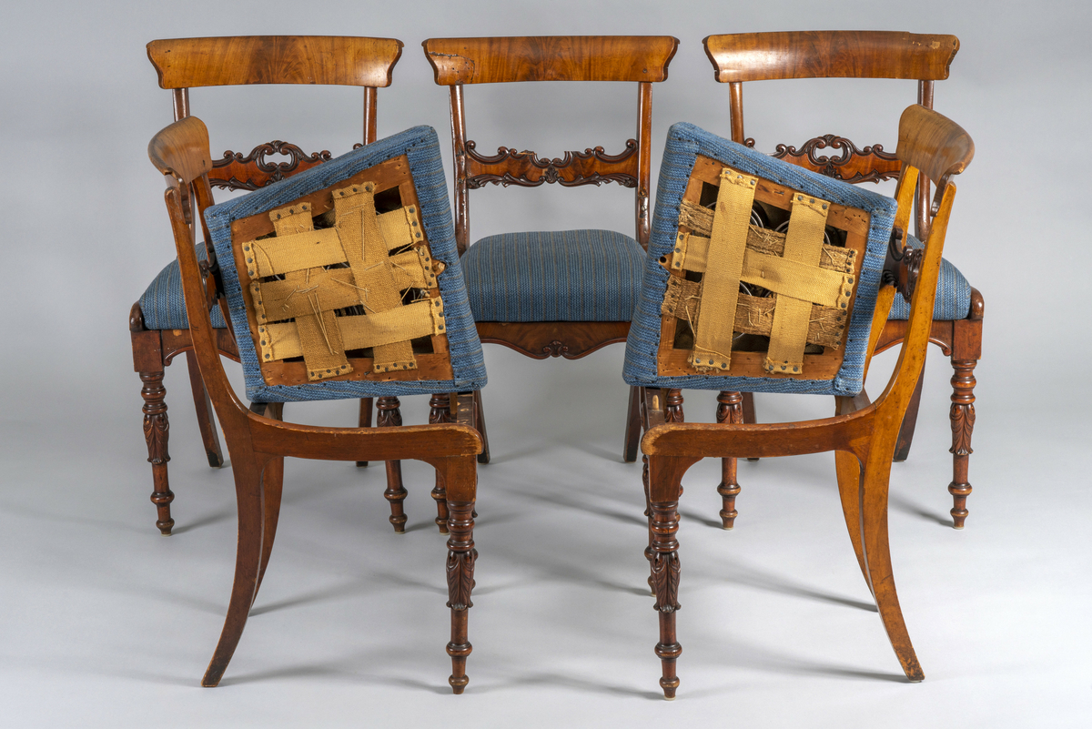 5 like spisestuestoler i utskåret, beiset bøk, med felter av finert mahogni eller valnøtt. Noen skader i treverk. Løse, trukne seter i stripete, blått trekk med 4 kraftige fjærer i hver. Stolrammer og puter er merket med romertall, men satt sammen uten hensyn til disse.  Har tilhørt Sara Fabricius.