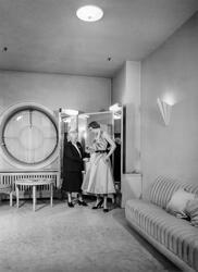 Kvinna provar prickig klänning i provrummet vid NK:s Franska