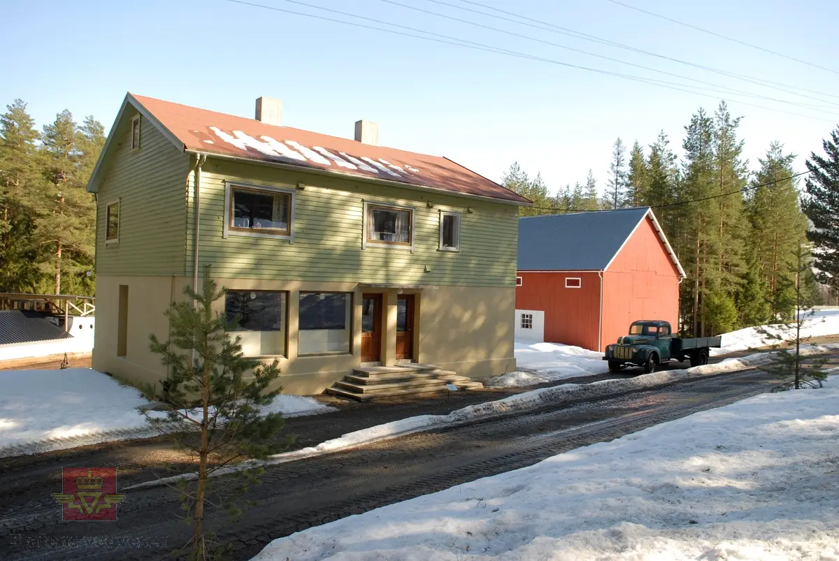 5 bilder av Blindheimsvik landhandel som ble flyttet til Norsk vegmuseum i 1995.

Blindheimsvik landhandel ble bygget i 1950 på Vigra i Giske kommune i Møre og Romsdal og var i drift som butikk frem til 1970 og som bolighus til 1992. Butikken ble drevet av Olav og Olga Blindheimsvik.

Norsk vegmuseum fikk tilbud om å kjøpe stedet med våningshus, butikk og uthus. Det ble tatt befaring i 1994 og høsten 1995 ble bygningene med alt interiør fotodokumentert slik det sto på Vigra. Alt interiøret ble pakket ned og fraktet i containere til Norsk vegmuseum. Alle bygningsdeler ble merket før det ble tatt ned. Murvegger og piper ble ikke flyttet, men revet. 

9. juni 2007 ble Blindheimsvik landhandel, leilighet og uthus gjenåpnet på Norsk vegmuseum. Ansvarlig for flytting og gjenreising var: Aslak Stø, Magnar Jevnehagen, Dagfinn Sveen og Per Stø.

(Kilde: Norsk vegmusum)

Bilde 1) Bildet viser Blindheimsvik landhandel, trolig fra 1950-tallet.
På bildet står en 1945 modell Ford lastebil. Lastebilen hører til bygningene. 
På bildet står også en Oldsmobile 1938 modell parkert. (Informant Ivar E. Stav)
Foran står 3 barn, en jente og to gutter. (Foto: Ukjent fotograf.)
Bilde 2) Bildet viser innevendig interiør slik butikken opprinnelig var. (Foto: Ukjent fotograf. )
Bilde 3 og 4) Blindheimsvik  landhandel med uthus slik den framstår i dag ved Norsk vegmuseum. På ene bildet står Ford lastebilen. (Foto: Ole A. Flatmark.)
Bilde 5) Bildet viser et eksempel på vareutvalget i butikken på Norsk vegmuseum (Foto: Ole A. Flatmark.)