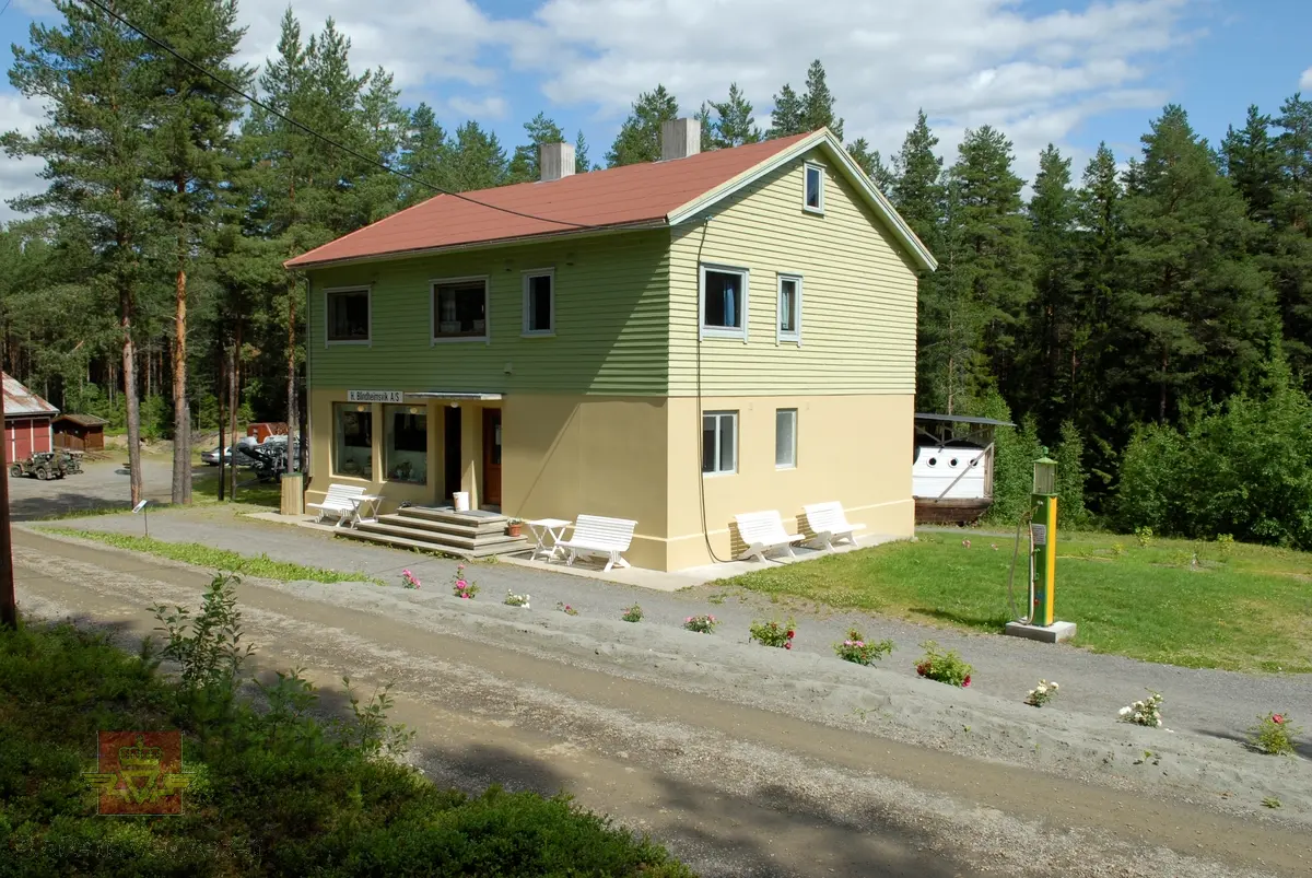 5 bilder av Blindheimsvik landhandel som ble flyttet til Norsk vegmuseum i 1995.

Blindheimsvik landhandel ble bygget i 1950 på Vigra i Giske kommune i Møre og Romsdal og var i drift som butikk frem til 1970 og som bolighus til 1992. Butikken ble drevet av Olav og Olga Blindheimsvik.

Norsk vegmuseum fikk tilbud om å kjøpe stedet med våningshus, butikk og uthus. Det ble tatt befaring i 1994 og høsten 1995 ble bygningene med alt interiør fotodokumentert slik det sto på Vigra. Alt interiøret ble pakket ned og fraktet i containere til Norsk vegmuseum. Alle bygningsdeler ble merket før det ble tatt ned. Murvegger og piper ble ikke flyttet, men revet. 

9. juni 2007 ble Blindheimsvik landhandel, leilighet og uthus gjenåpnet på Norsk vegmuseum. Ansvarlig for flytting og gjenreising var: Aslak Stø, Magnar Jevnehagen, Dagfinn Sveen og Per Stø.

(Kilde: Norsk vegmusum)

Bilde 1) Bildet viser Blindheimsvik landhandel, trolig fra 1950-tallet.
På bildet står en 1945 modell Ford lastebil. Lastebilen hører til bygningene. 
På bildet står også en Oldsmobile 1938 modell parkert. (Informant Ivar E. Stav)
Foran står 3 barn, en jente og to gutter. (Foto: Ukjent fotograf.)
Bilde 2) Bildet viser innevendig interiør slik butikken opprinnelig var. (Foto: Ukjent fotograf. )
Bilde 3 og 4) Blindheimsvik  landhandel med uthus slik den framstår i dag ved Norsk vegmuseum. På ene bildet står Ford lastebilen. (Foto: Ole A. Flatmark.)
Bilde 5) Bildet viser et eksempel på vareutvalget i butikken på Norsk vegmuseum (Foto: Ole A. Flatmark.)