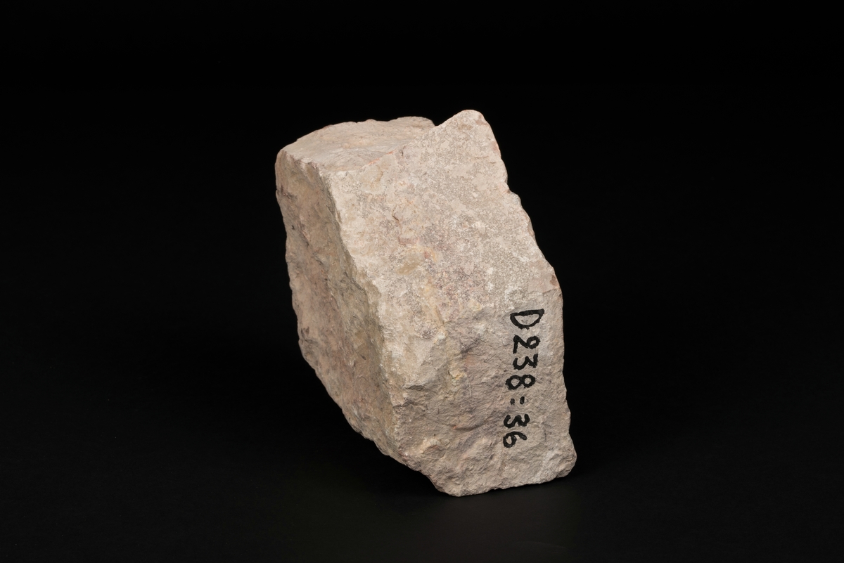 Gravstensfragment tillverkad av huggen kalksten.
Inhuggen inskrift "OLA" med nedsänkta majuskler.