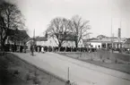 Medborgartåget, Växjö 1940, passerar Askelövsgatan vid nuvarande Oxtorget. I bakgrunden skymtar Ringsbergsskolan.