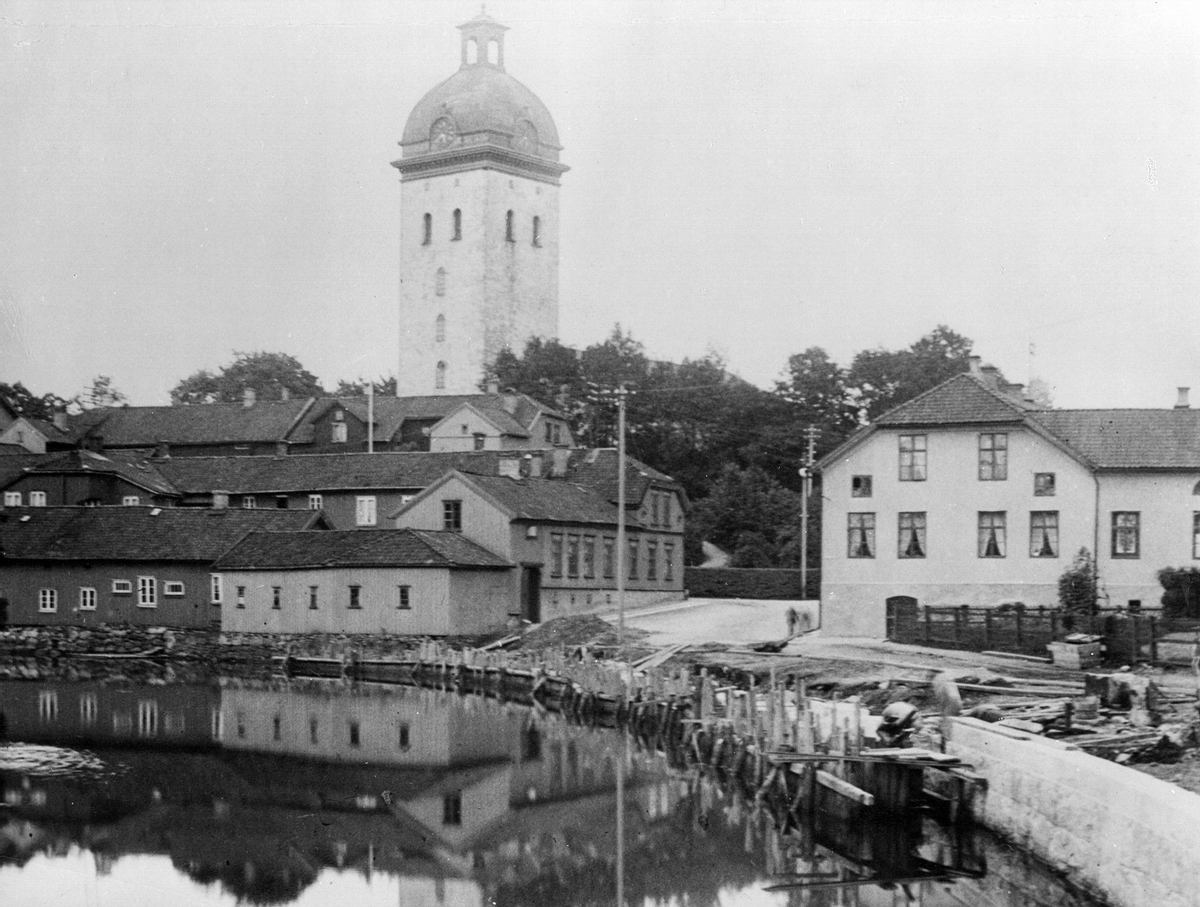 Vy från Viskan nedanför Carolikyrkan och Grönvallen med Berglundska gården och Hotell Metropol i slutet av 1800-talet.
