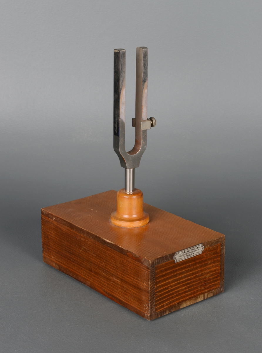 Stemmegaffel av stål montert på rektangulær resonanskasse av tre. Kassen er åpen i en ende og står på filtføtter. På gaffelen er inngravert "a1 435". Fra C. Monsens Skolemateriellhandel, Bergen. Brukt i fysikkundervisning til å studere gjenklang.