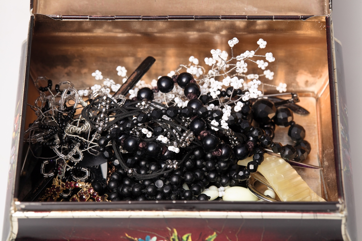 Skrinet er rektangulært, har fire små stetter, gulbrunt under, det utvider seg noe, men er likevel bare 1 cm bredere øverst enn nederst. Skrinet er brunt og har tegninger av blomster og blad. På lokket er en tegning av to hester som trekker en elegant vogn, i denne sitter glade mennesker av begge kjønn.
