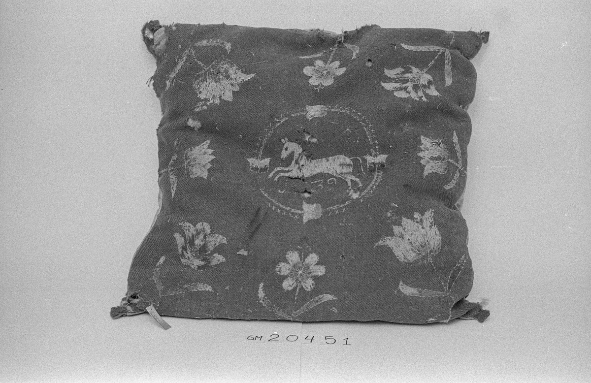 Pute av ull brodert med blomster- og dyremotiv og med underside av skinn