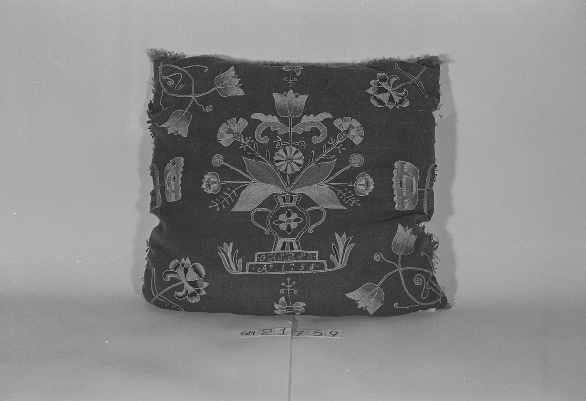 Pute av ull brodert med blomstermotiv og med underside av skinn