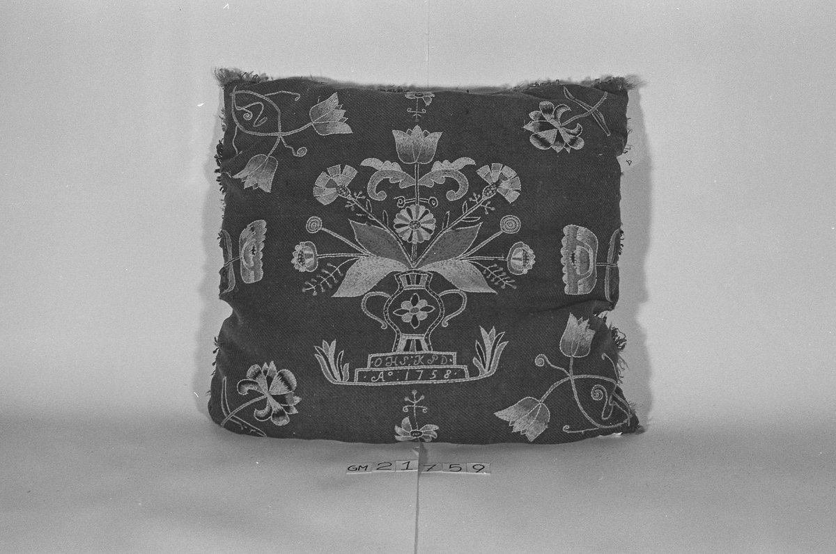 Pute av ull brodert med blomstermotiv og med underside av skinn