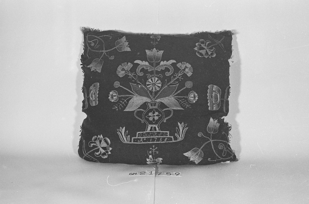 Pute av ull brodert med blomstermotiv og med underside av skinn