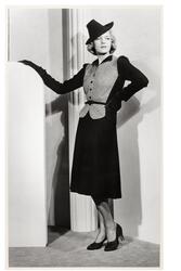 Mannekäng visar dräkt. Höftlång, figurnära jacka med liten k