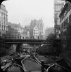 Skioptikonbild med motiv av arbete med  lastade pråmar på kanal i Hamburg.
Bilden har förvarats i kartong märkt: Resan 1906. Hamburg 9.