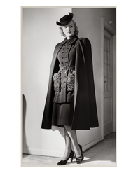 Mannekängen Margit Langlet visar ytterplagg i provrum. Dräkt