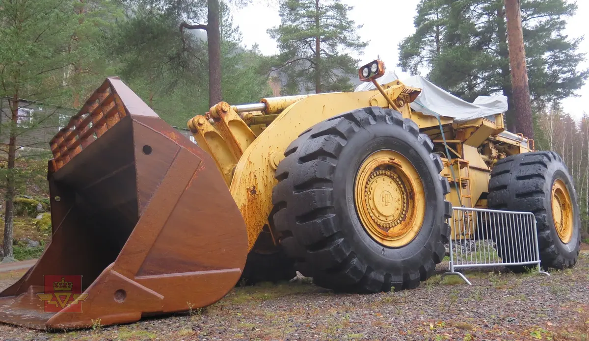 International H-400C Payloader. Hjullaster på 4 hjul, antatt 4-hjuls drift. Gul og svart. Motoren er en turboladet V12 Cummins type VT1710C-635. Dette er en 4-takts diesel med et cylindervolum på 1710 cu. in. (28 liter), Effekt 473.5 kw (635 hp). Skuffa rommer ni kubikkmeter.
Girkasse fra International Harvester, modellbetegnelse P-600S (to-trinns). Merking fra produsent og første bruker.
