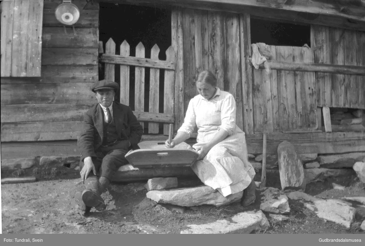 Sylfest Forberg (f. 1899) ved sida av budeia, Torø Forberg (f. 1890 g. Tundrali), som rører i osten ca. 1920