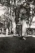 En man i kostym (P G Vejde?) håller tal vid Carl von Linnés byst i Linnéparken, trol. 1947. I bakgrunden syns en handfull åskådare.