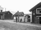 Parti av Linköping år 1899, närmare bestämt Nygatan 42 vid skärning med Apotekaregatan. Byggnaderna illustrerar den enklare trähusbebyggelsen som länge dominerade stadsbilden. Brandgavlarna som skymtar i bakgrunden visar ändå på den nya tiden där stora stadsmässiga bostadshus börjar förändra stadsbilden.