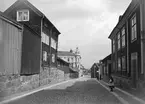 Parti av Linköping 1901, Nygatan mot öster sedd från korsningen av Klostergatan. Till höger Mamsell Dufvas gård. Längre ned på gatan skymtar Saluhallen från 1888 och bortom denna ses en snedställd gavel som förklaras av Trädgårdstorgets då vinkelställda västra sida. I bildens vänstra del ses det så kallade Trasberget, där bagare Jacob Lind senare kom att uppföra sitt affärshus. Stenhuset i fonden uppfördes 1885 i italiensk nyrenässans och är den enda byggnaden på bilden som ännu är bevarad.