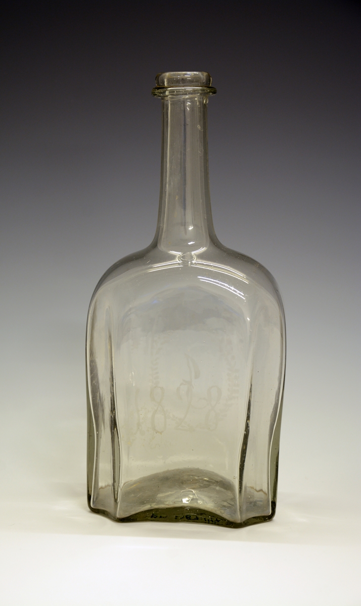 Glasskaraffel. Innrisset bokstaven "J" i oval bladranke og "1828".