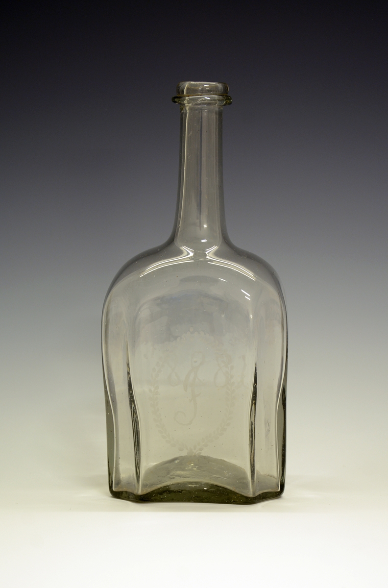 Glasskaraffel. Innrisset bokstaven "J" i oval bladranke og "1828".