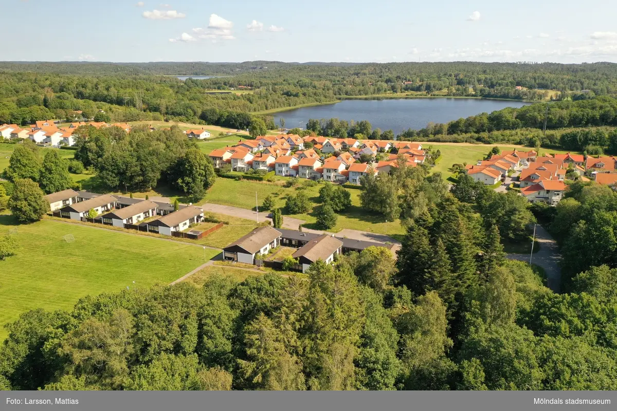 Flygfotografi som visar bebyggelse i Stretered, Kållered, i Mölndals kommun. Vy mot nordost. Närmast ses kamhusen Änggården och längst bort Backegården, Stretered 1:106, med gatuadresser Ängbackevägen 21-27 och 13-19. Därefter följer nyare bostadsbebyggelse vid samma gata samt, i bakgrunden, Tulebosjön. Byggnadsdokumentation inför rivning. Fotografi taget av Mattias Larsson, Borohus AB, den 23 augusti 2021.