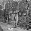 Motiv från Sandbäcksgatan 14 i Linköping. Bostadshuset uppfördes i Tinnerbäcksravinen under 1900-talets första år och placerades som synes alldeles intill bäcken. Här dokumenterat 1968 inför planerad rivning, vilket emellertid kom att dröja till början av 1970-talet.