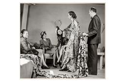 Mannekäng visar mönstrad klänning för tre kvinnliga kunder s