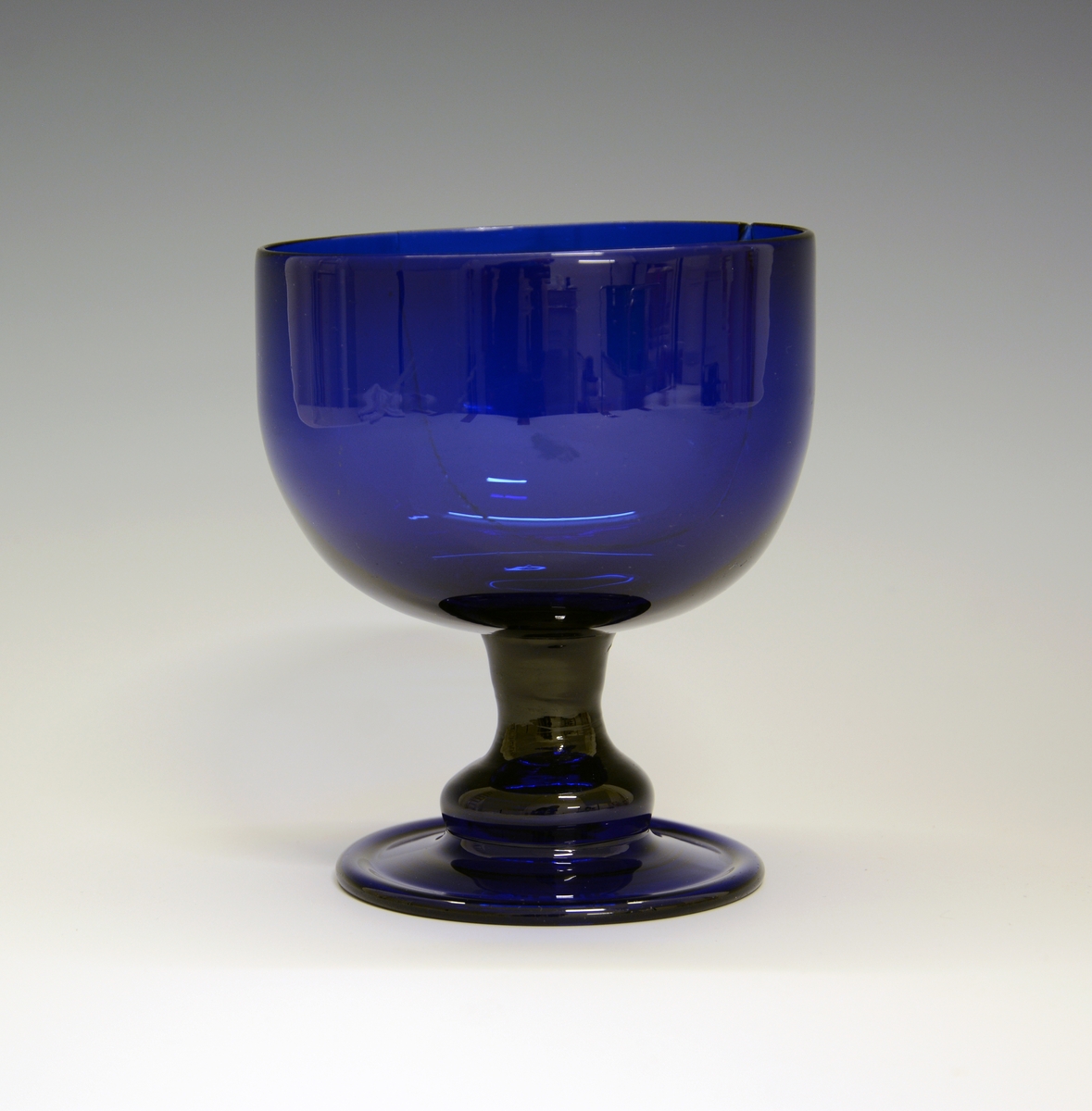 Sukkerkopp på stett. Fra protokollen: Sukkerkop av blaat glas. Form som et glas paa fot. Lidt lavere og videre.