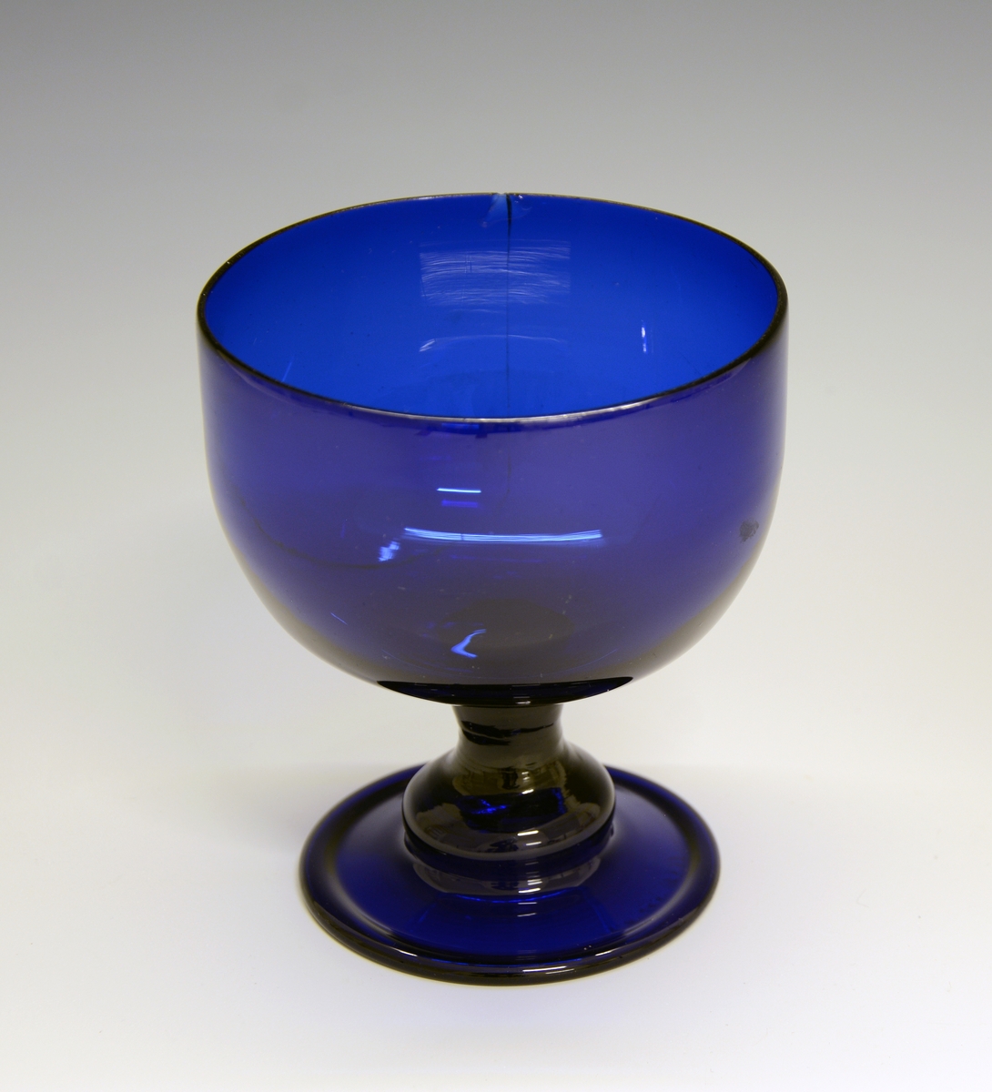 Sukkerkopp på stett. Fra protokollen: Sukkerkop av blaat glas. Form som et glas paa fot. Lidt lavere og videre.