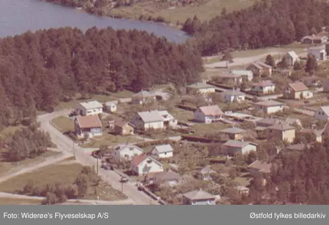 Flyfoto av boligområde på Brevik i Tune.
Tunevannsveien går forbi det som i dag er parkering ved Tunevannet og videre opp forbi Lækkert. Madam Arnesens vei komme ut ved det blå huset.