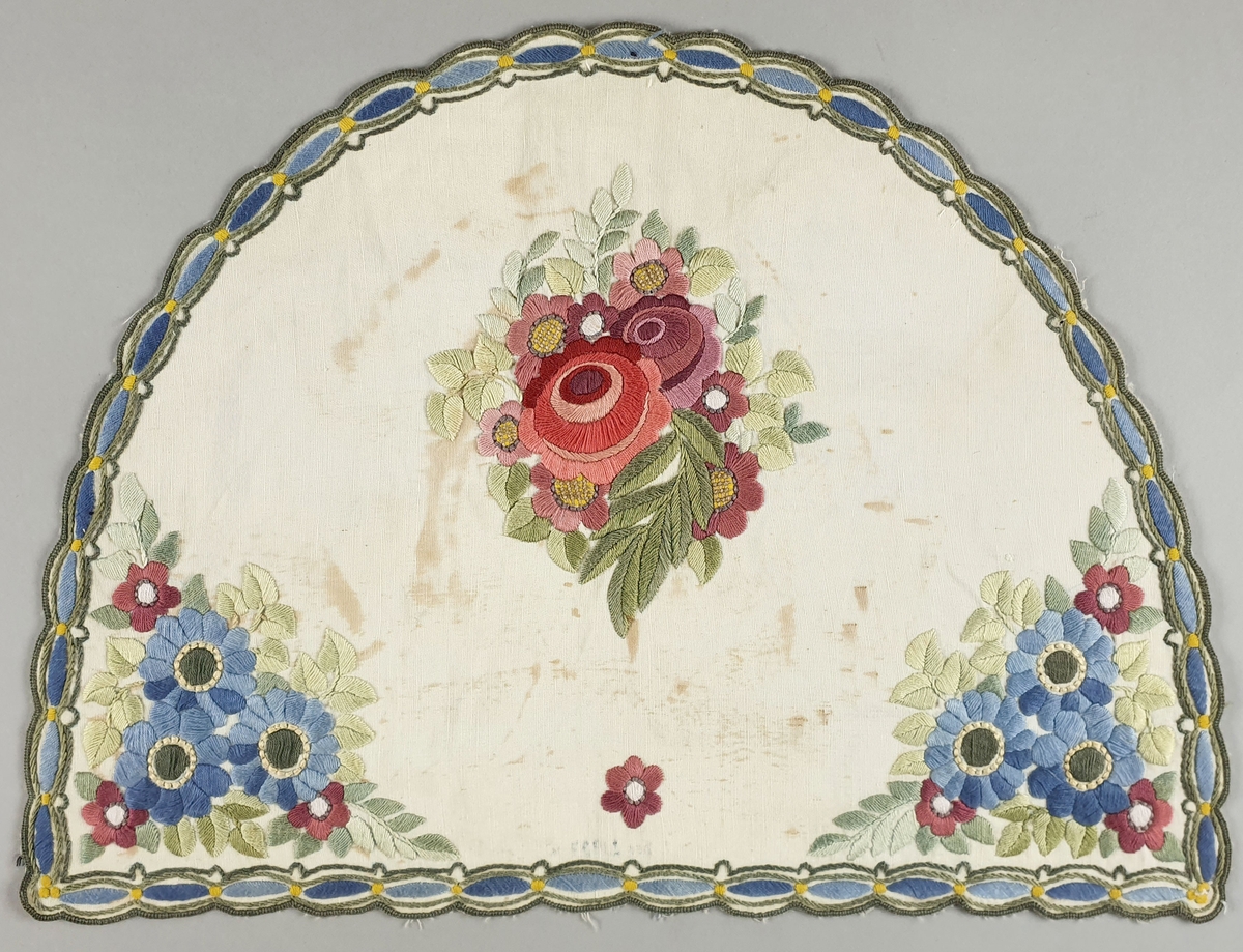 To halvsirkelformede duker - forside og bakside - den ene med broderinger av blomster og bård rundt kanten.