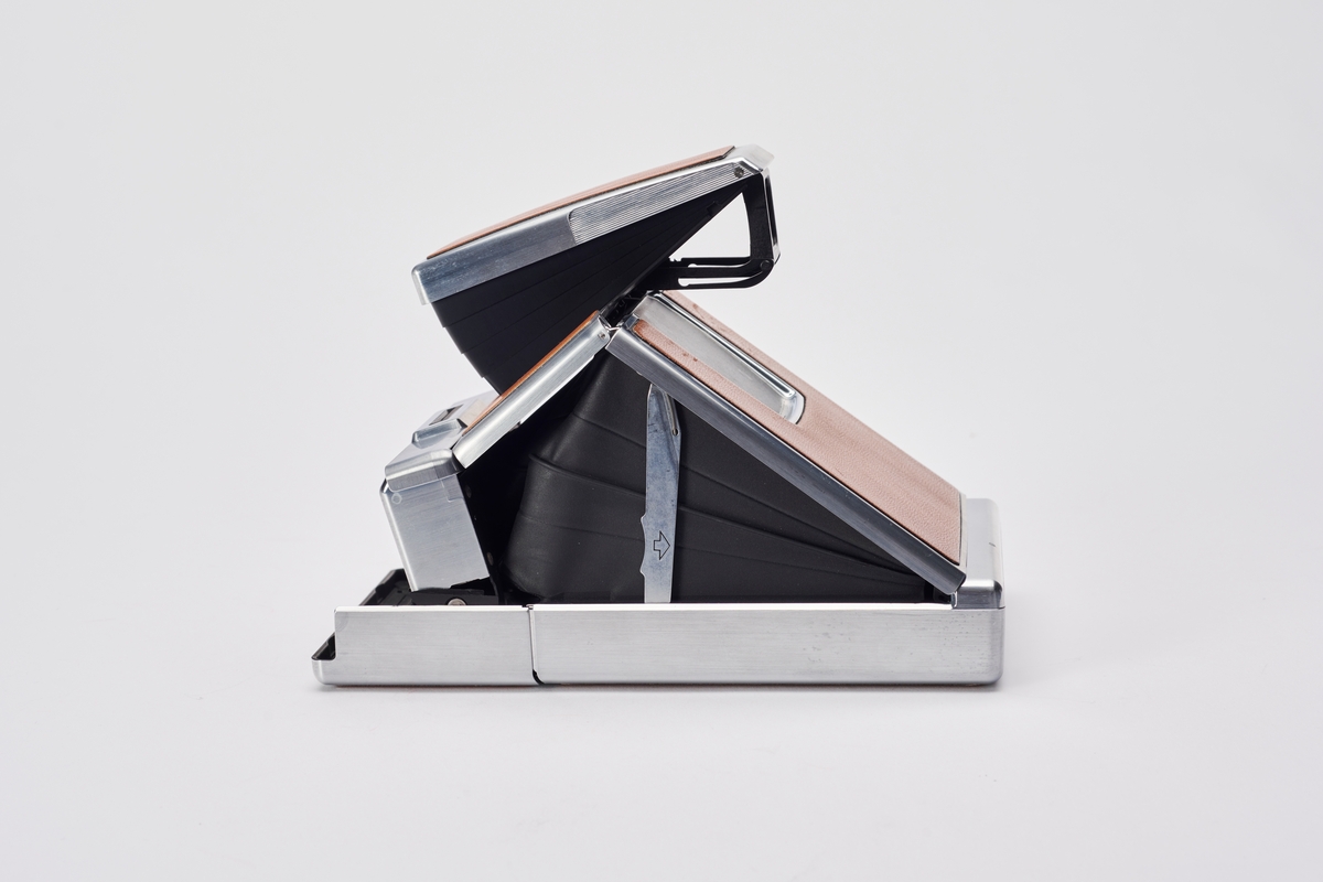 SX-70 Land Camera ble produsert av Polaroid på 1970-tallet og revolusjonerte direktebildefotograferingen. De to første modellene er avanserte speilreflekskameraer, som kan foldes sammen. Designet var spesielt og filmen var den første med en ny type bildeframstilling. Det var det første systemet som produserte et ett-trinns direktefotografi. 
Filmene lå enkeltvis i en kassett. Hvert bilde var en forseglet pakke som inneholdt et negativ, kjemikalier og et positiv. Bildet kom automatisk ut av kameraet og kunne sees i løpet av 2 minutter, men trengte noen minutter til før det fikk sitt endelige uttrykk. I filmkassetten var også batteriet som ga strøm til kameraet og blitsen.