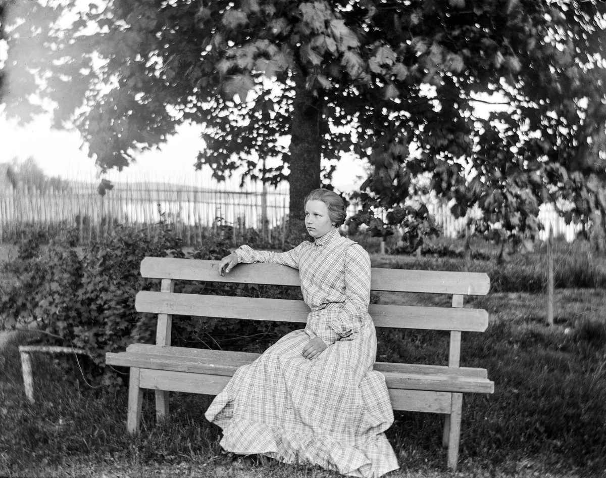 Dame sittende på en hagebenk.
