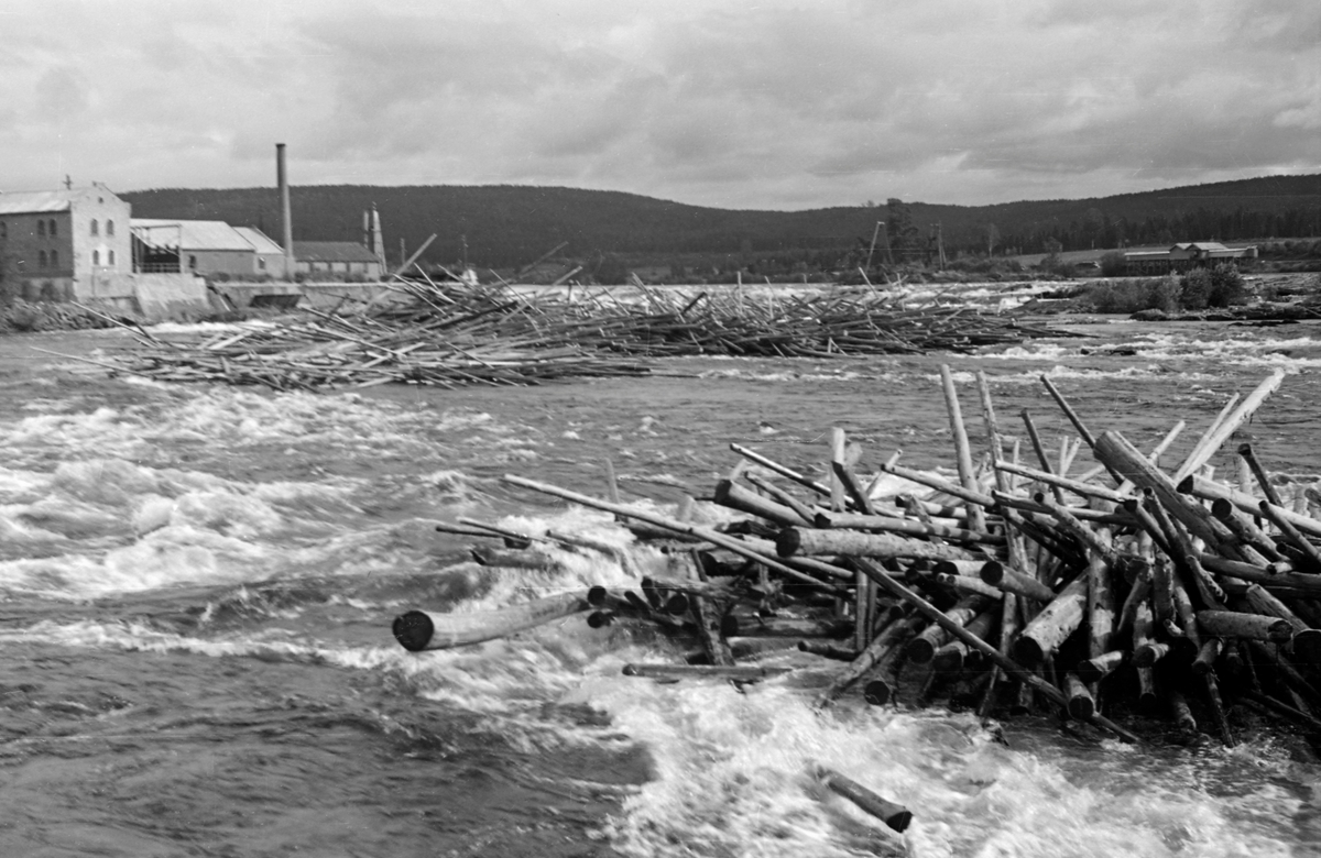 Tømmervaser eller tømmerhauger i Funnefossen i Glomma. Dette fossefallet ligger lengst nord i Nes kommune på Romerike. Fotografiet er tatt i medstrøms retning. Funnefossen har et samlet fall på bortimot 11 meter, fordelt over en strekning på drøyt 800 meter. I fossen var et en del steinskjær der fløtingsvirket som kom flytende fra ovenforliggende skogbygder hadde lett for å sette seg fast, spesielt hvis vannføringa var lav. Noe av energien i fossefallet ble utnyttet av treforedlingsbedriften Funnefoss tresliperi. Vi ser deler av fabrikkomplekset, som var utført i teglmur, til venstre i dette bildet. Denne bedriften ble bygd for Anders Olai Haneborg i midten av 1870-åra. Det var tilførselen av tømmer fra vassdraget, energien i fossen og jernbaneforbindelsen mot hovedstaden som var de viktigste lokaliseringsfaktorene. I 1918 gikk Haneborg konkurs, og Sør-Odal kommune overtok fabrikken og de tilhørende skogeienommene. Kommunen var nok mest interessert i fallrettighetene i fossen, og leie bort tresliperiet. Alt i 1919 ble det ødelagt av brann. Fabrikken ble gjenoppbygd i 1920 og gjenoppsto som A/S Nye Funnefoss Træsliberi. Tresliperiet var i drift fram til 1966.