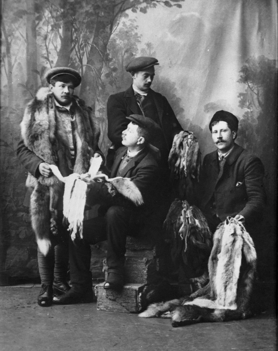 Fire menn med skinnvarer fotografert i et fotoatelier. Bildet er tatt i forbindelse med Rørosmartnan