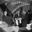 Christian Diors besök på NK, Nordiska kompaniet i Stockholm februari 1957. Kurt Jacobsson visar en stickad tröja.