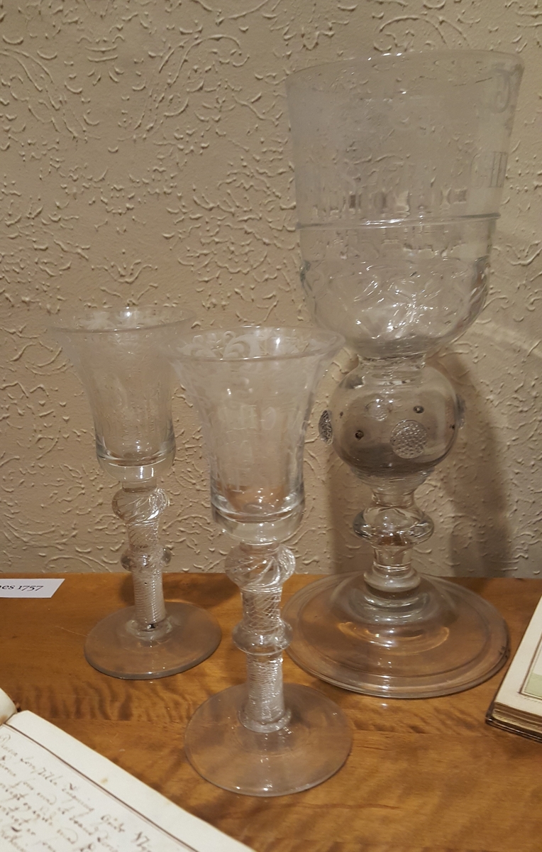 Seks glass. Rund fotplate, to runde former på stettet Klokken er smalnende midt på glasset og videst langs munningsranden.
