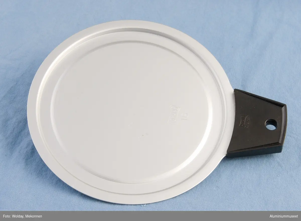 Teknikk: Lokket ble utstanset og presset i ett slag i eksenterpresse. Utgangsmaterialet var lange platerimser. Håndtaket ble utstanset i 45 grader i forhold til platelengden for å spare  materiale. Lokket ble  natureloksert og et bakelitt-håndtaket ble preget fast til lokket.
Fra 1940 til 1960 ble lokkene presset fra ferdig utstansede skillinger fra Valseverket. Lokkene ble presset, automatpolert, lokket og klinket sammen med bakelitt-håndtaket.
Form: Flatt, rundt lokk med bakelitt-håndtak preget fast til leppe i kanten på lokket.
