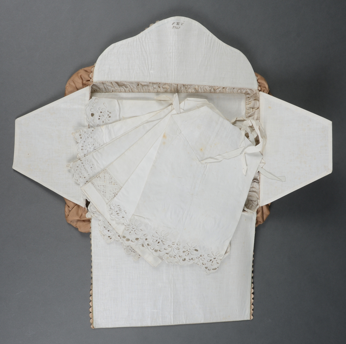 Rektangulær mappe med gjennomhullet broderi, "Venetiansk søm". Bunnen og lokkdelen er avstivet med en papp-plate, foret med hvitt chintzstoff. Sidene er av sammenrynket stoff som er sydd til bunnen og lokkdelene for hånd. Sidene er foret med samme stoff som bunn og lokkdelene. Under de broderte delene er det trekt med grønt silkestoff. Mappen inneholder 5 1/2 par mamelukker. 
Mamelukk 07, 1 singel, har brodert tungekant og engelskbroderi, håndsydd søm på utsiden og indresøm på innsiden av mamelukken, 2 knyttebånd.
Mamelukker 08, 1 par, har brodert tungekant og engelskbroderi, håndsydd, indresøm på ut- og innsiden av mamelukken, opprinnelig 2 knyttebånd på hver.
Mamelukker 09, 1 par, har innfelt mellomverk av kniplinger, 1 knyttebånd på utsiden i øvre kant, sømmene er håndsydde, indresøm på innsiden.
Mamelukker 10, 1 par, påsydd engelskbrodert kant, søm på innsiden av mamelukken, håndsydd, 2 knyttebånd på hver.
Mamelukker 11, 1 par, har brodert tungekant og engelskbroderi, håndsydd, indresøm på innsiden, opprinnelig 2 knyttebånd på hver.
Mamelukker 12, 1 par, påsydd engelskbrodert kant, søm på innsiden av mamelukken, håndsydd, 2 knyttebånd på hver.