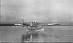 Flygplan S 5, Heinkel He 5 Hansa, nr 2473 med flottörer kör på vatten, ca 1927-1935. Vy bakifrån. Eventuellt på sjön Roxen.