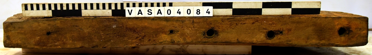 Lavettsida höger med tre trappsteg. Bit framför axelläget är borta. Torkad, missfärgat, svårt skadad på främre hörn. 
 

Right gun cheek. Dried, discoloured, heavely damaged on front top corner. Remounted  with hardware.