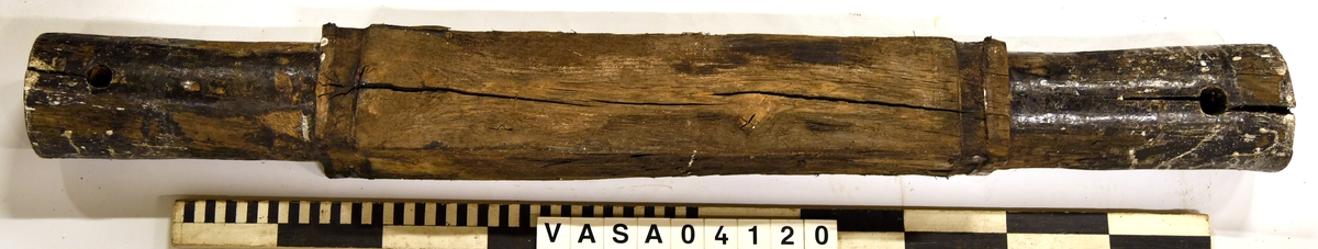 Lavettaxel fram. Välbevarad med två hål för tränagel. 

Axle front edge of a gun carriage, good condition, two large pin holes.